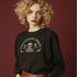 Christmas sweatshirt with "SEASONS SCREAMINGS, DARKLING" text arched over a skull wearing Santa hat. Bats, flowers, and ornate designs surround the skull in vintage-inspired style.